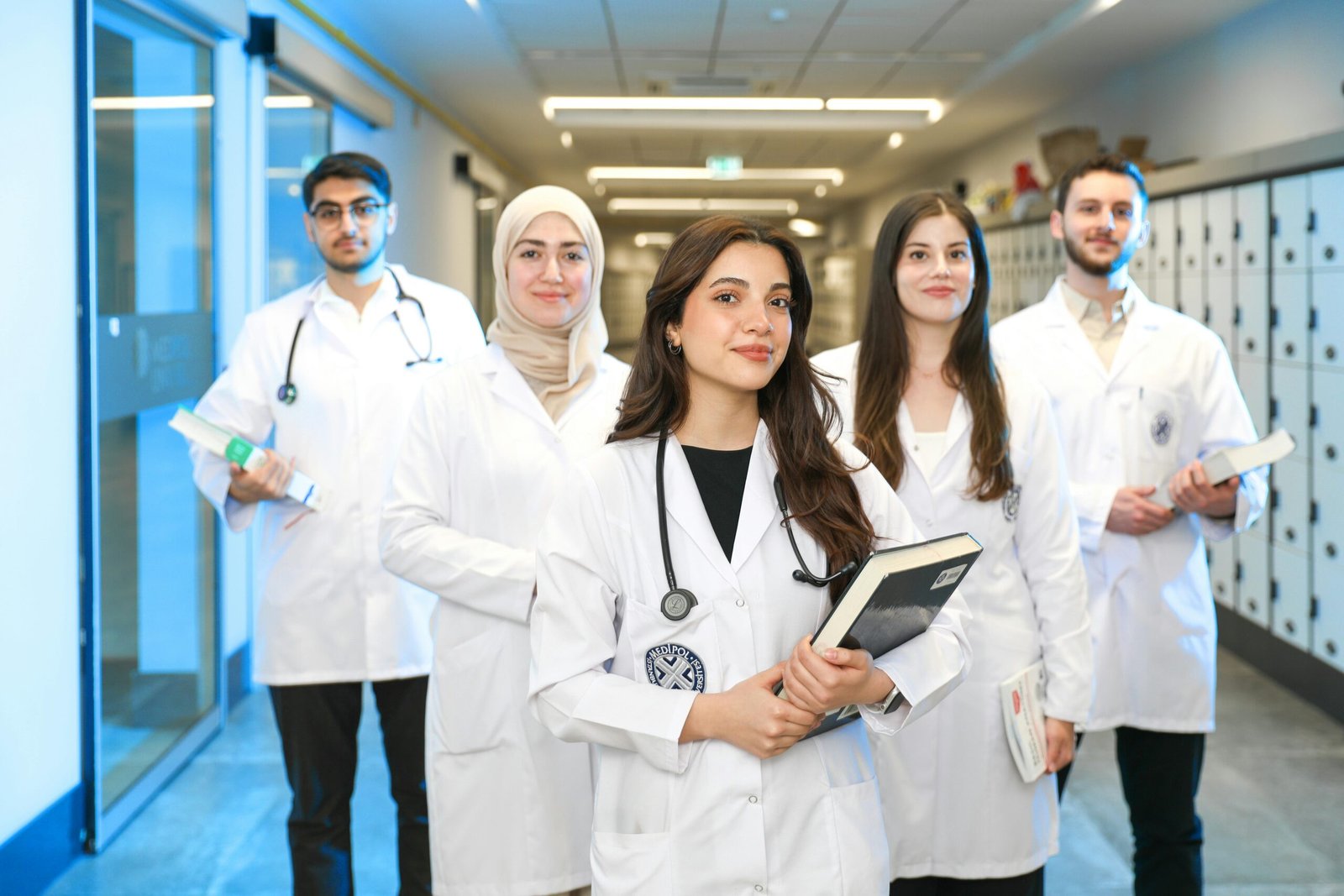Home Group of diverse medical students wearing lab coats in university corridor, representing future healthcare professionals.