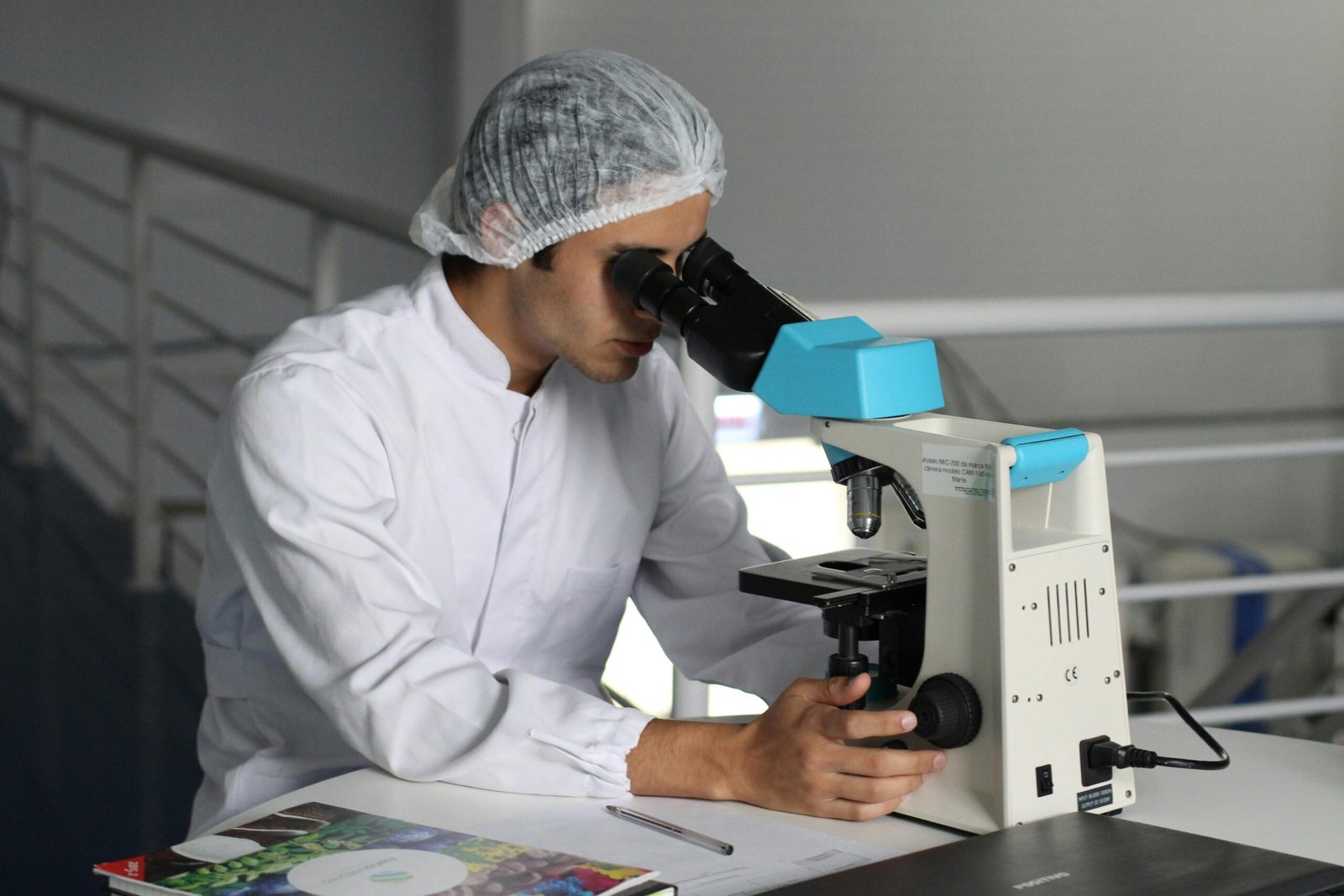 Academics Scientist in a lab coat using a microscope to conduct research, focusing on healthcare improvements.