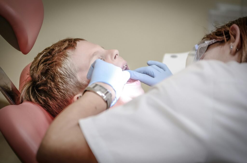 Certificate Courses A young boy receiving a dental examination by a professional dentist in a clinic setting.
