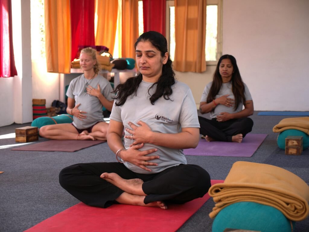 Bachelor Courses Pregnant women practicing calming prenatal yoga in a serene Rishikesh studio.